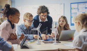 teacher and middle school kids using computers in classroom representing cybersecurity in schools
